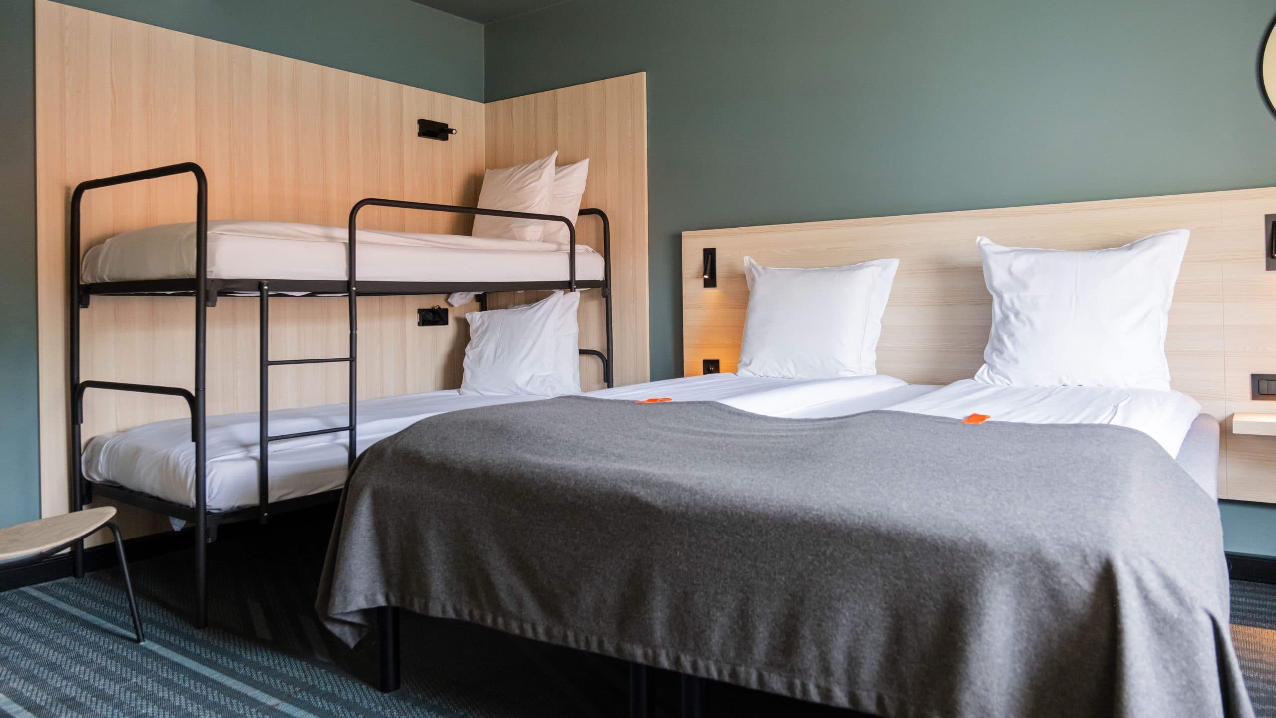 Overview image of a family room at Citybox Brussels showing a double bed and bunk beds