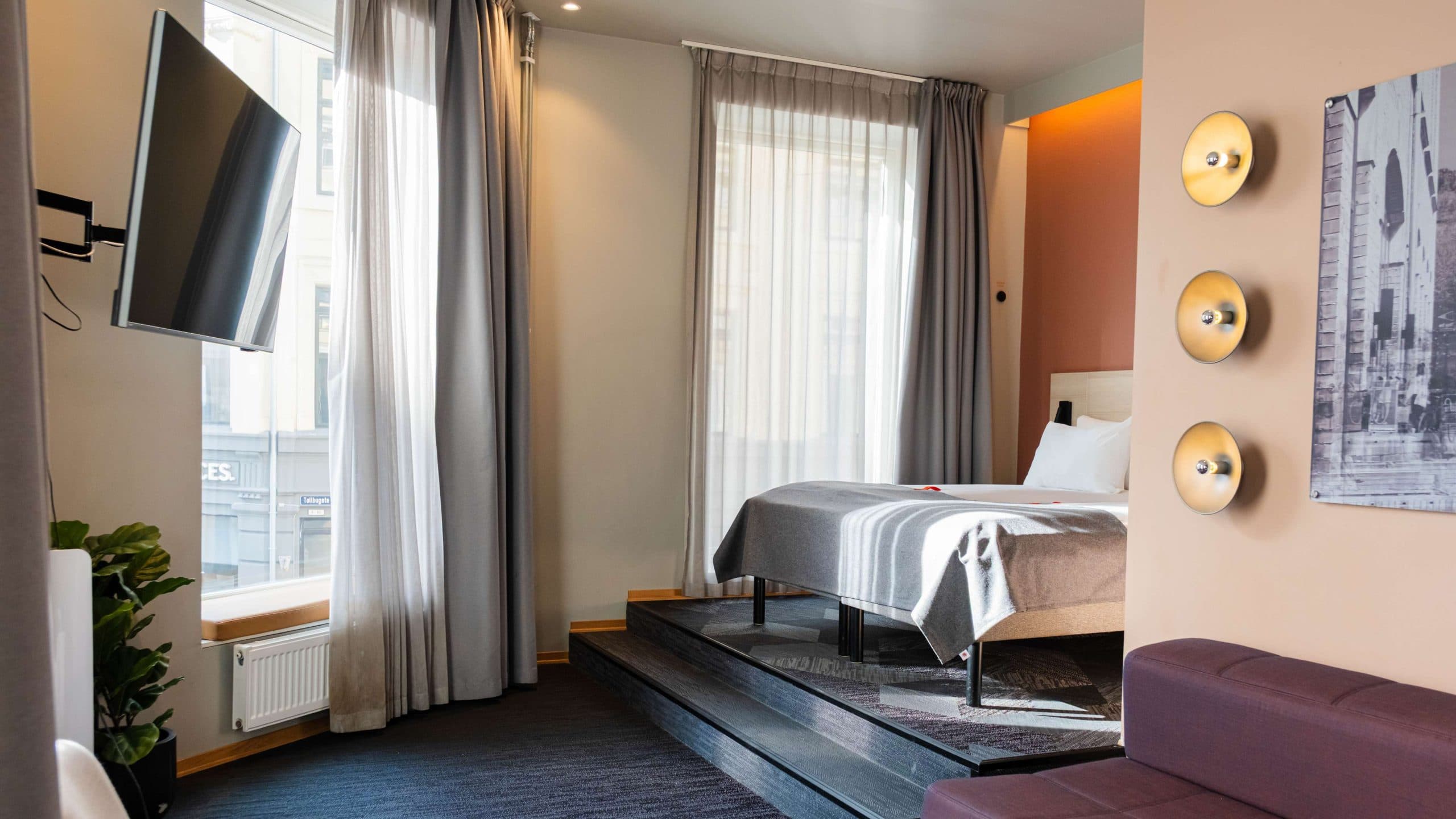 Overview picture of junior suite at Citybox Oslo showing TV, bed and seating area